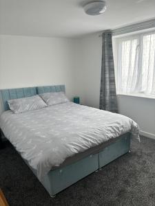 een bed in een witte slaapkamer met een raam bij Duke of Albany in Weymouth