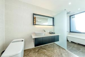 a bathroom with a sink and a mirror and a tub at Arts Spa&Poolvilla in Jeju