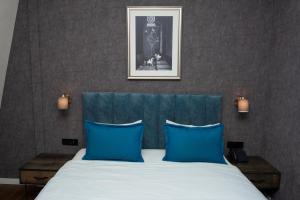a bedroom with a bed with blue pillows at Port Rivoli Baku Luxury Boutique Hotel in Baku