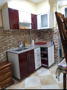 a kitchen with a sink and a brick wall at Jijel location F3 avec piscine plein air in Jijel