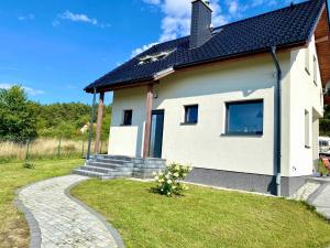 a white house with a pathway leading to it at Ferienhaus Seeblick in Wisełka