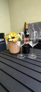 dos copas de vino en una mesa con una cesta de flores en La Dolce Vita - Apartment with shared pool and large terrace, en Lido delle Nazioni