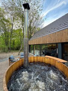 una fuente de agua frente a una casa en Tető Mátra Nordic Cabin, en Mátraszentimre