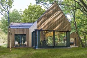 a house with a gambrel roof and large windows at Tető Mátra Nordic Cabin in Mátraszentimre +3 photos
