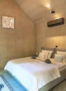 1 dormitorio con 1 cama blanca grande en una habitación en Tető Mátra Nordic Cabin, en Mátraszentimre