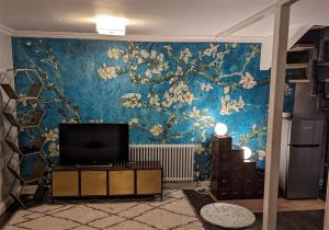 ein Wohnzimmer mit einem TV und einer blauen Wand in der Unterkunft Folka Rocks in Folkestone