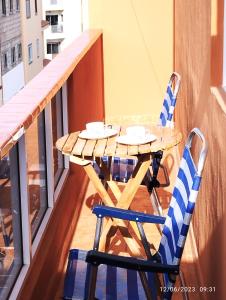 ein Holztisch und zwei Stühle auf einem Balkon in der Unterkunft Balcon del sur con vista mar in Arona