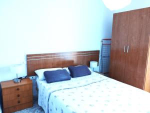 ein Schlafzimmer mit einem Bett mit zwei blauen Kissen darauf in der Unterkunft Balcon del sur con vista mar in Arona + 26 Fotos