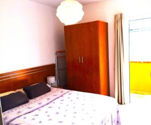 ein Schlafzimmer mit einem Bett, einem Schrank und einem Fenster in der Unterkunft Balcon del sur con vista mar in Arona