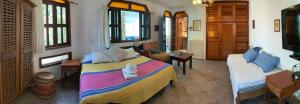 een slaapkamer met een groot bed en een bank bij Hotel Gilda in Coyuca