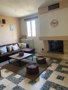 a living room with a couch and a fireplace at Location appartement 1 chambre et dépendance en sus dans un mas provençal au coeur du luberon in Cavaillon