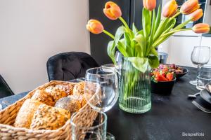 una mesa con una cesta de pan y un jarrón de flores en Liegeplatz - vollausgestattete Wohnungen - zentrumsnah, en Brunsbüttel