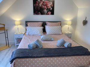 een slaapkamer met een groot bed met blauwe kussens bij Chambre d'Hôtes Salamandre in Lanvollon