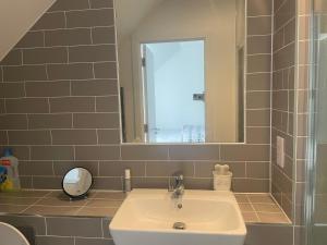 uma casa de banho com um lavatório e um espelho em Serene Stay Sanctuary em Romford