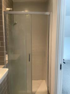 a shower with a glass door in a bathroom at Serene Stay Sanctuary in Romford