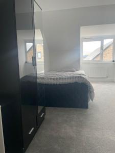 a bedroom with a bed and a glass cabinet at Serene Stay Sanctuary in Romford