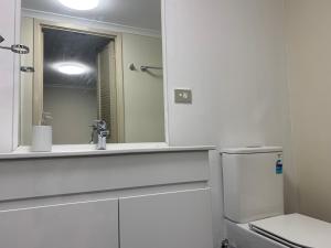 a bathroom with a sink and a mirror at Broadway Central Apartment in Sydney