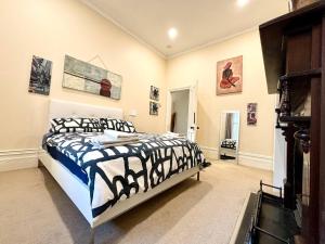 ein Schlafzimmer mit einem Bett und einige Bilder an der Wand in der Unterkunft Subiaco Heritage House "gem"! in Perth