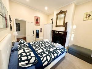 Schlafzimmer mit einem Bett, einem Kamin und einem Spiegel in der Unterkunft Subiaco Heritage House "gem"! in Perth + 39 Fotos