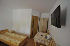 a small room with a bed and a flat screen tv at willa grazyna 2 in Dźwirzyno