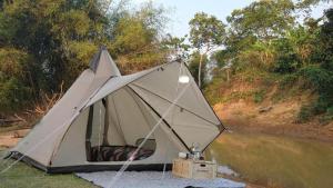 een witte tent aan de kant van een rivier bij สวนภาคินรัตน์ 