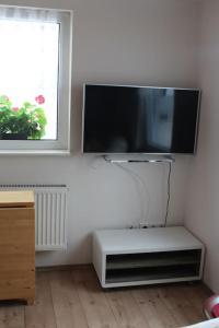 uma sala de estar com uma televisão de ecrã plano na parede em Kleines Häuschen am Garten in Darmstadt em Darmstadt