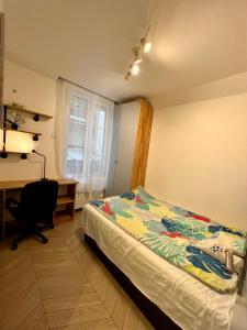 1 dormitorio con cama, escritorio y ventana en La Résidence Panthéonique en París