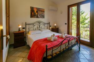 a bedroom with a bed with two stuffed animals on it at SanVitoTour- Residence Il Baglio in San Vito lo Capo