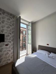 a bedroom with a bed and a large window at Binario 14 Piazza Garibaldi in Naples