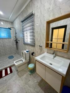 a bathroom with a sink and a toilet at Private Apartments in a Home in Ejisu