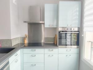a kitchen with white cabinets and a stove at L'Organik Disney 7 min Gare 5 min parking privé in Chessy +13 photos