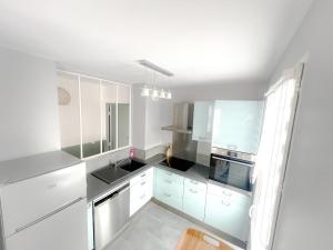 a kitchen with white cabinets and a sink at L'Organik Disney 7 min Gare 5 min parking privé in Chessy