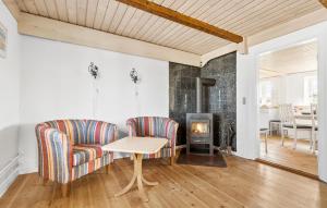 a living room with two chairs and a table and a fireplace at Nice Home In Grenaa With Wifi in Grenå