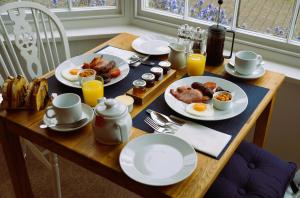 a table with plates of breakfast food on it at Radcliffe Guest House in Ross on Wye