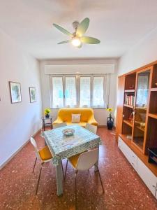 a living room with a table and a yellow couch at A Due Passi Dal Mare in Lido di Camaiore
