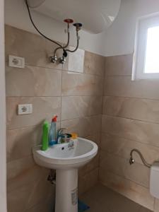 ein Badezimmer mit einem weißen Waschbecken und einer Dusche in der Unterkunft Tusha Vacation Home 