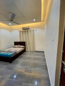 1 dormitorio con 1 cama y ventilador de techo en Private Apartments in a Home, en Ejisu