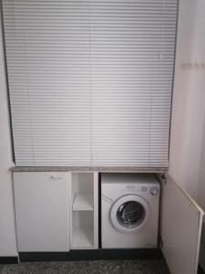 a window with a white blinds over a washing machine at Casa Gabry in Domodossola
