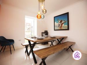 a dining room with a wooden table and a bench at Victoria House,5 Bed, Fantastic Location, Free Parking, Contractors in Cardiff