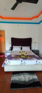 a bedroom with a bed with a bedspread with flowers on it at Snowdrop inn coorg in Madikeri