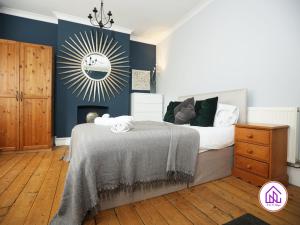 1 dormitorio con cama y espejo en la pared en Victoria House,5 Bed, Fantastic Location, Free Parking, Contractors en Cardiff