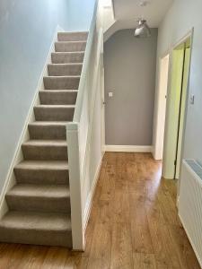um corredor vazio com escadas numa casa em Lovely, large double bedroom with park view, breakfast em Hazel Grove