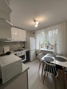 a kitchen with a table and a kitchen with a refrigerator at Tatiana apartment in Chişinău