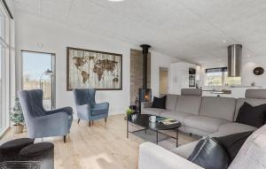 a living room with a couch and a table and chairs at Four-Bedroom Holiday Home Haderslev With A Room Hot Tub 09 in Knud