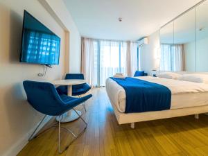 a hotel room with a bed and a table and chairs at Orbi City Black Sea view in Batumi
