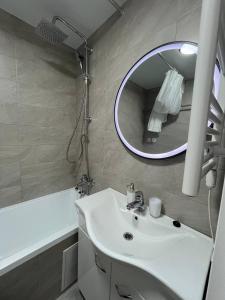 uma casa de banho com um lavatório e um espelho em Tatiana apartment em Chisinau