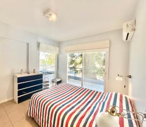 a bedroom with a bed and a large window at Terrazas del río Tigre. in Tigre