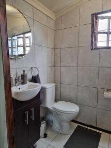 a bathroom with a toilet and a sink and a mirror at 11-on-RobRoy serenity glamping cabins overlooking the Valley of 1000 Hills in Hillcrest