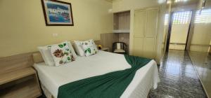 - une chambre avec un lit doté de draps et d'oreillers blancs dans l'établissement Hotel das Palmeiras, à Serra Talhada