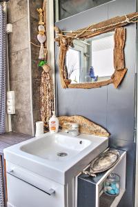 La salle de bains est pourvue d'un lavabo blanc et d'un miroir. dans l'établissement LA CABANE D'ISA, à Sète
